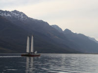 Catamaran sailing with mountains in the background