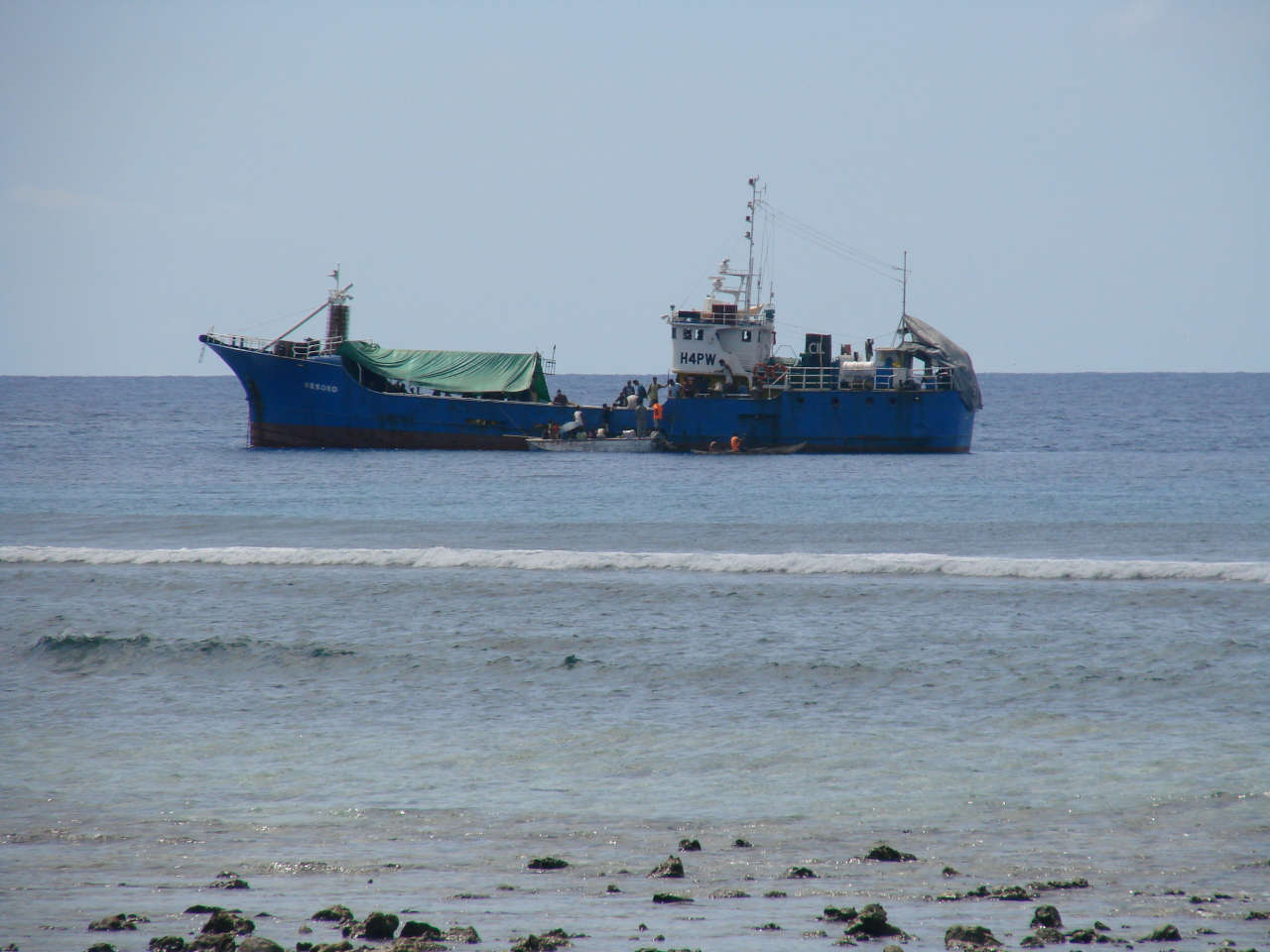 A blue cargo ship offshore