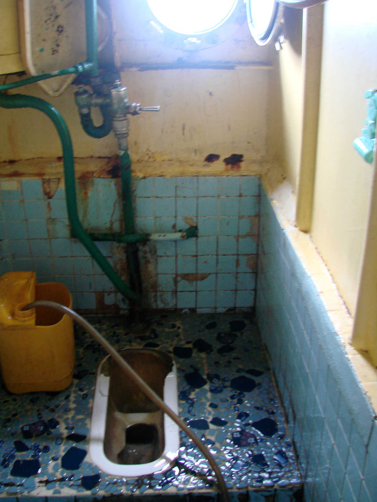 A shabby looking squat toilet