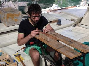 Giovanni with tools and workbench on deck