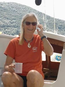 Hanneke on deck, smiling, holding a mug