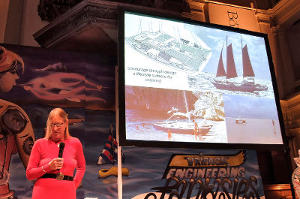 Hanneke Boon on stage, Wharram boats on a projector behind